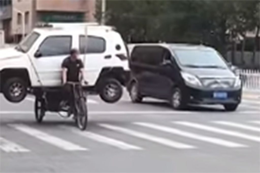 ХИТ СНИМАК: Кинез превозио ауто на бициклу (ВИДЕО)